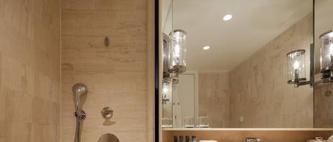 A modern bathroom with a shower, a vanity with a mirror, and a sink.