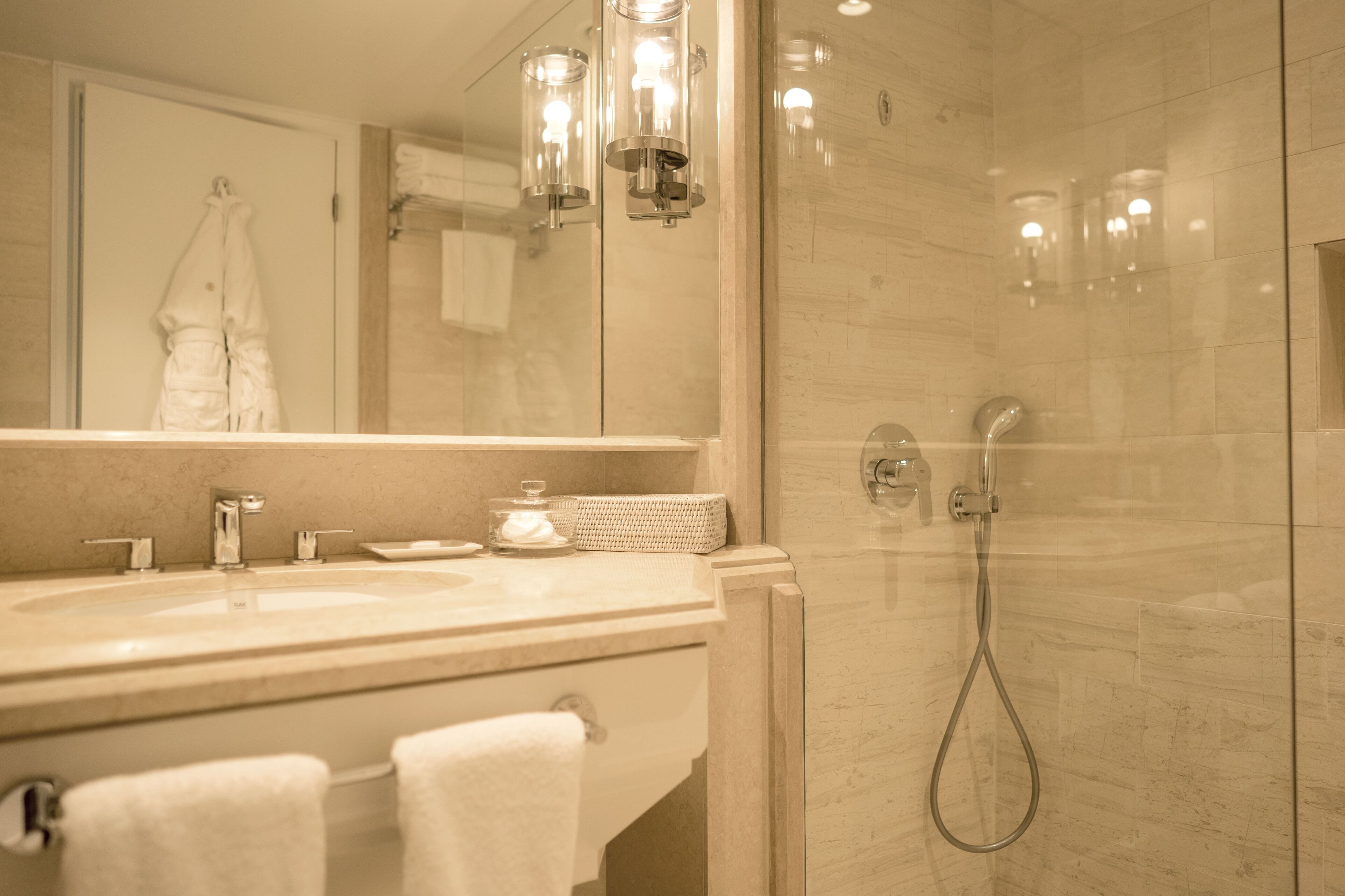 A modern bathroom with a glass-enclosed shower, a double sink vanity, and a large mirror.