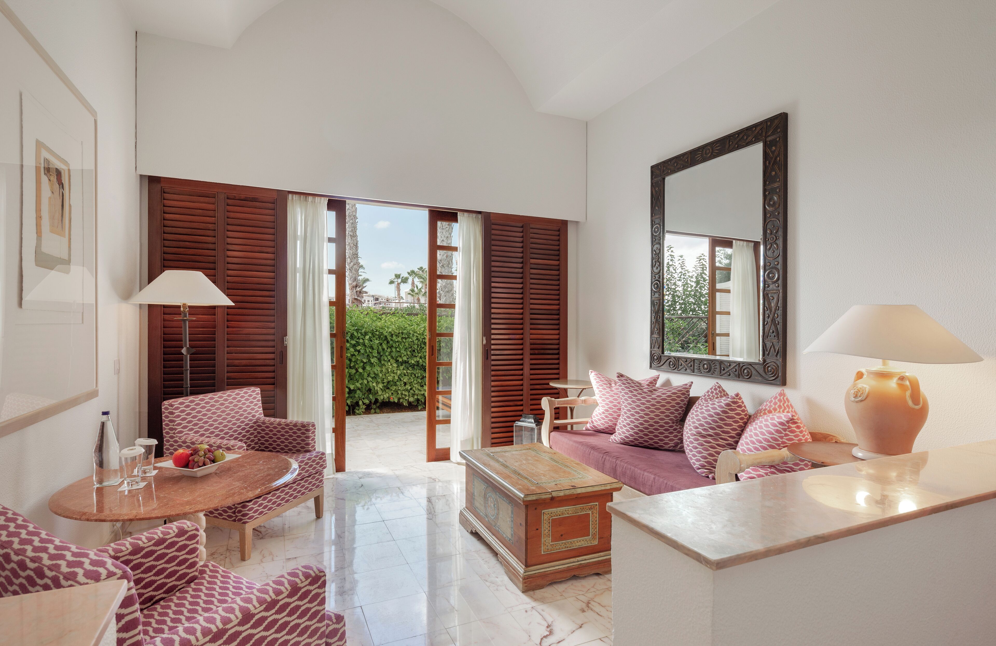 A spacious living area with a sofa set, a coffee table, and a side table with a lamp.
