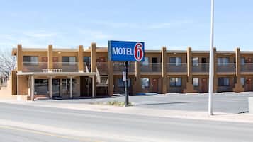 A Motel 6 building with a parking lot in front.