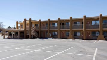 Un motel a più piani con un parcheggio di fronte.