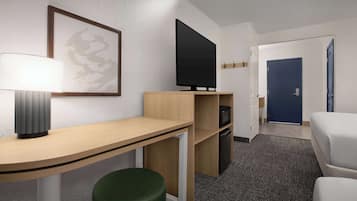 A hotel room with a desk, a green stool, a flat-screen TV, a framed artwork, a white bed, and a blue door.