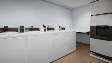 A laundry area with multiple washing machines and a refrigerator.