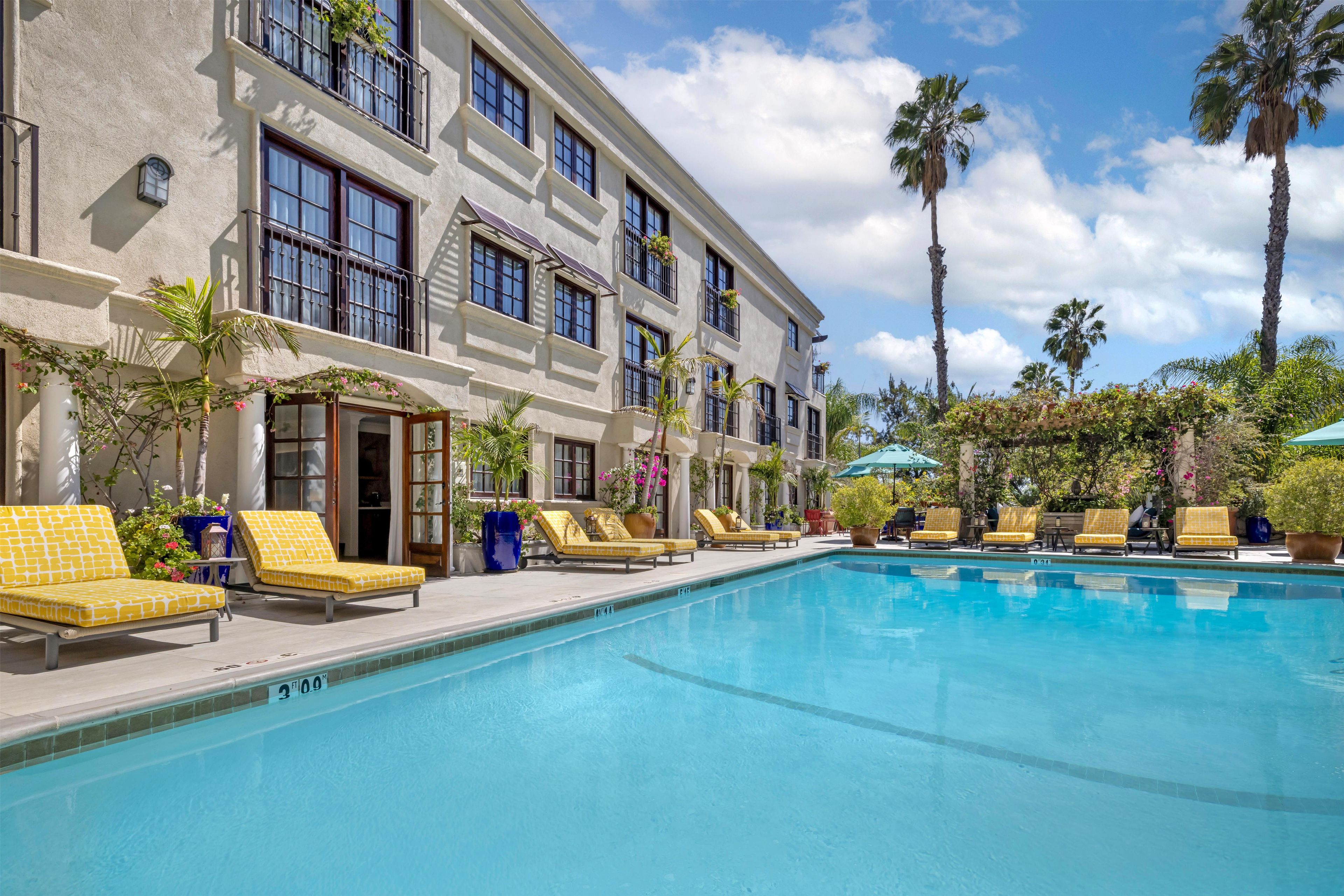 A poolside area with multiple sun loungers and a clear blue pool.