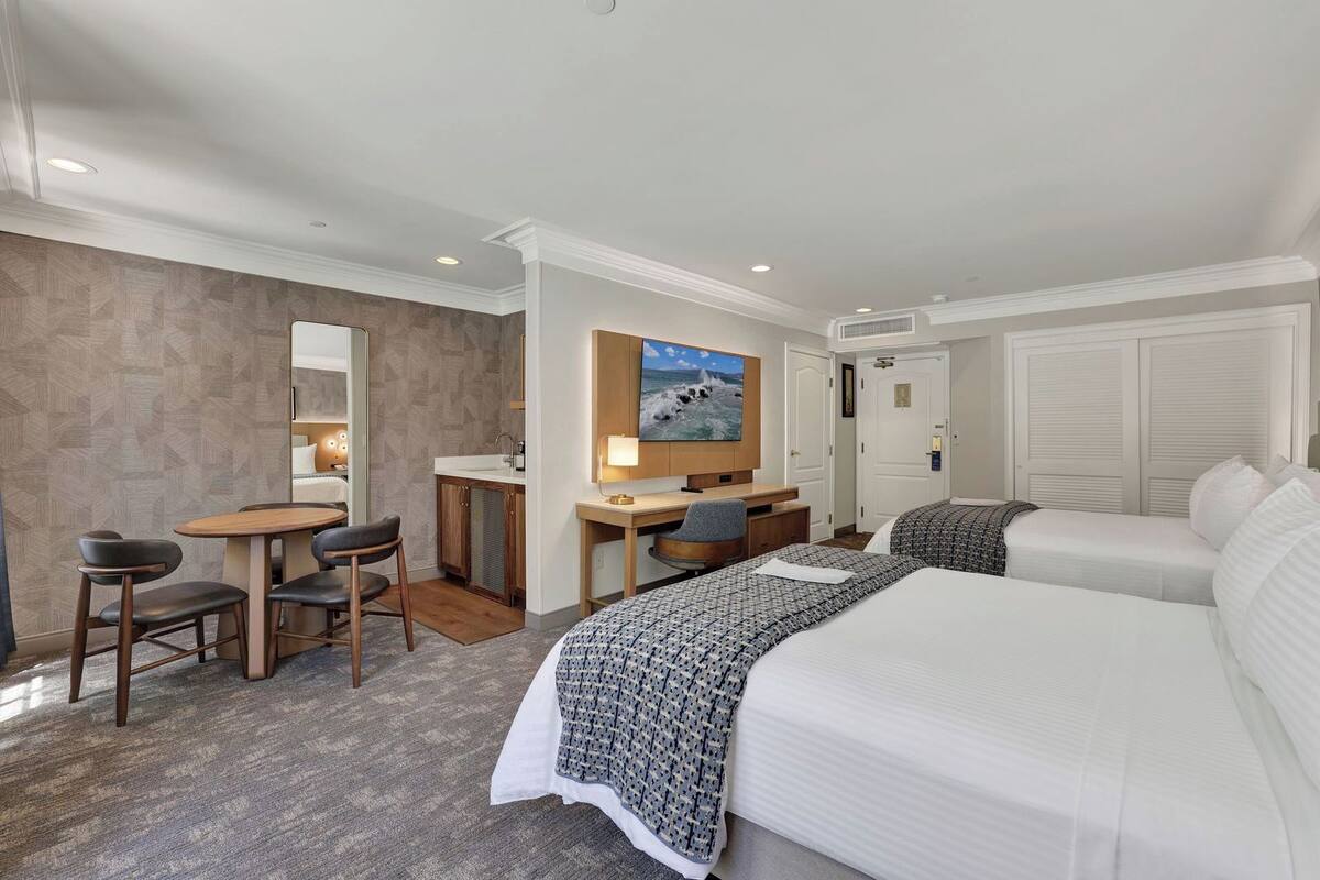 Une chambre d’hôtel comprenant un lit, un bureau avec une chaise, une télévision et une salle de bain.