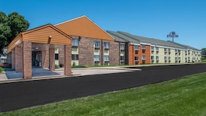 A Knights Inn with a brick facade, a covered entrance, and a parking lot. - Sunset Inn & Suites - Lincoln Airport (Lincoln)