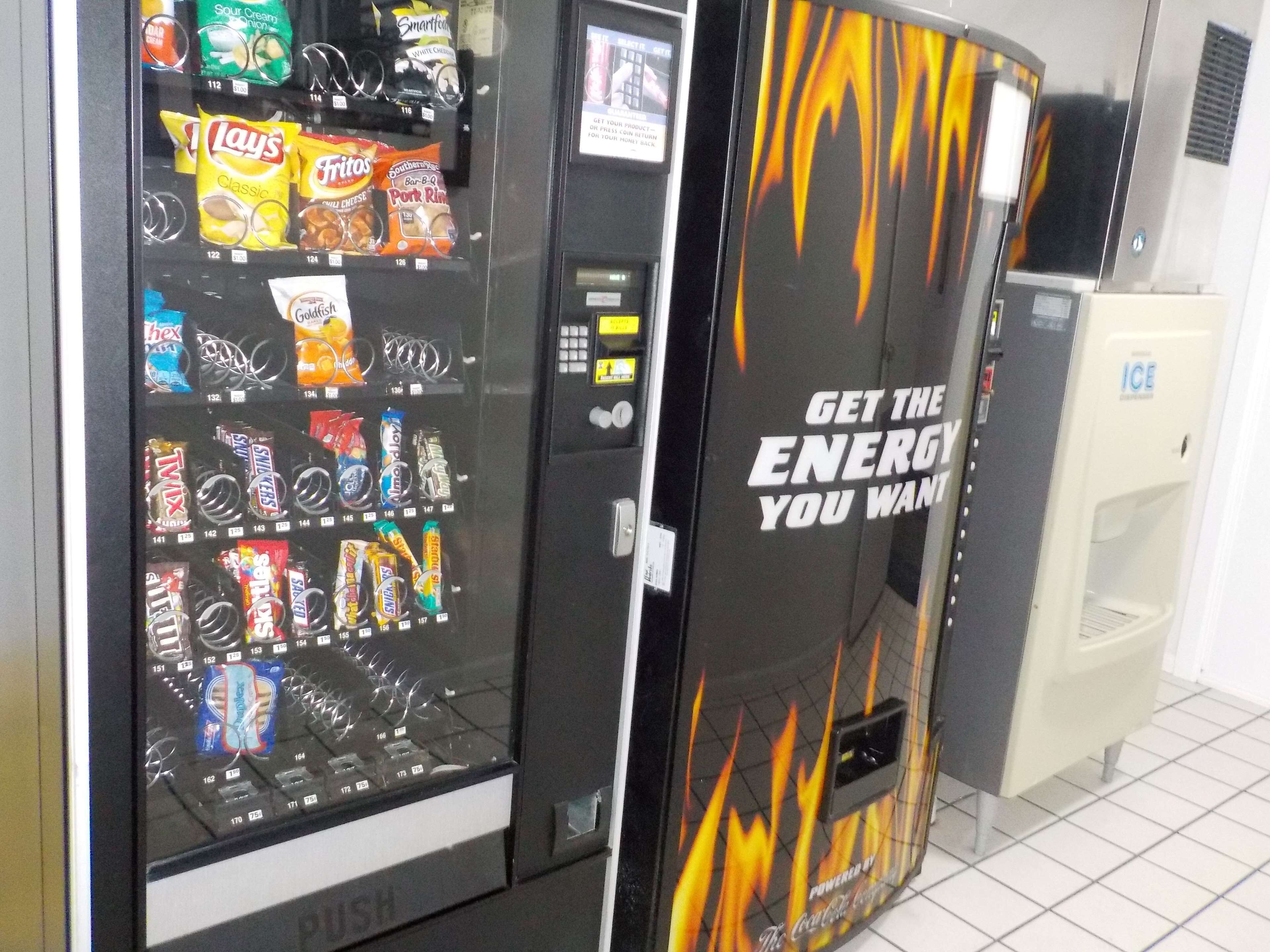 A vending machine with snacks and a Coca-Cola refrigerator.
