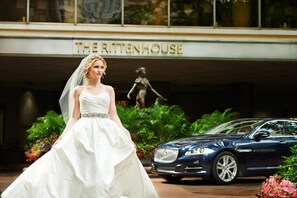 A wedding dress in front of a building with a statue and a blue car parked nearby. - The Rittenhouse Philadelphia (Philadelphia)
