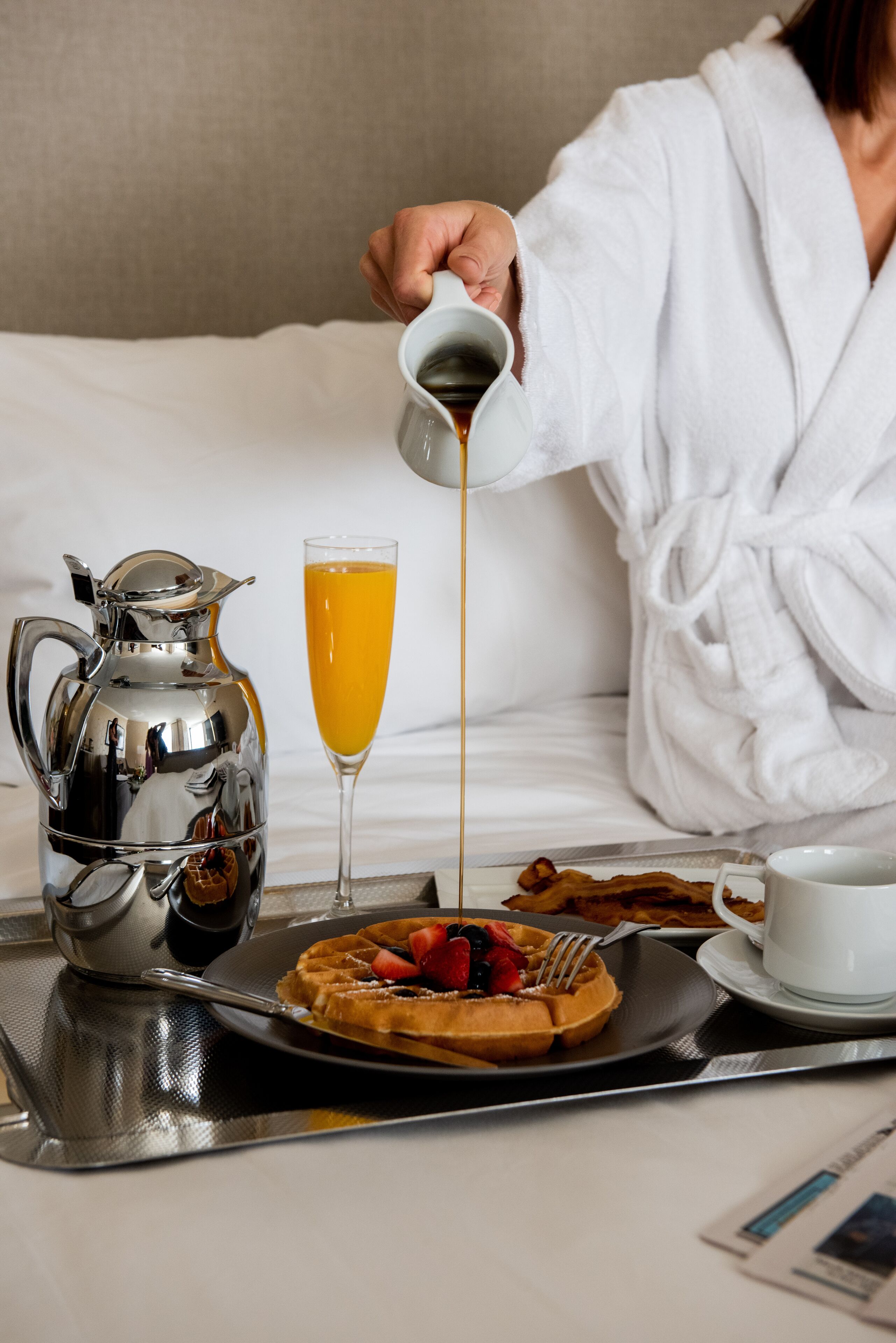A breakfast tray with waffles, a glass of orange juice, and a cup of coffee.