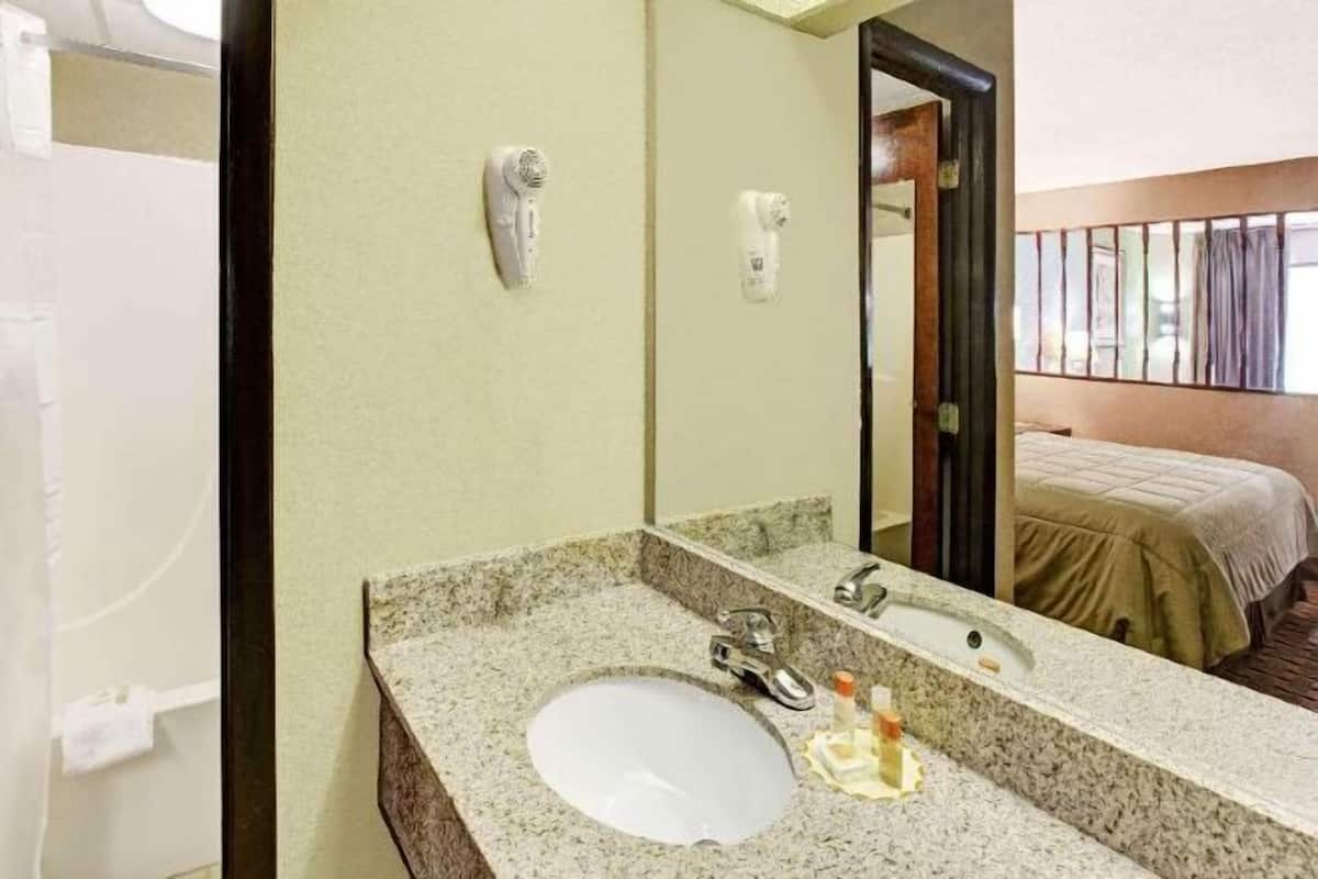 Badkamer | Een bad/douchecombinatie, een haardroger, handdoeken