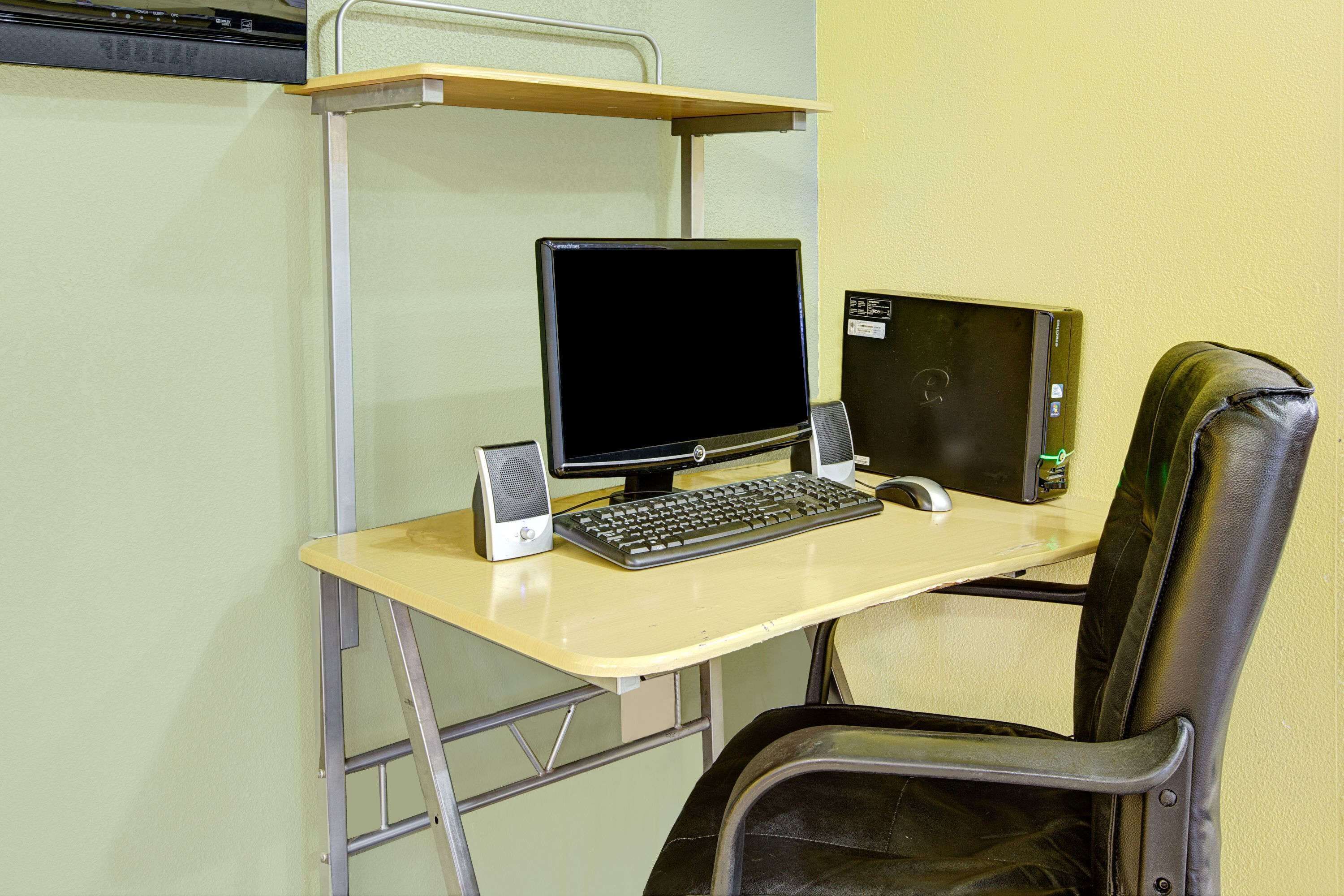 Una scrivania con un monitor, tastiera e mouse.