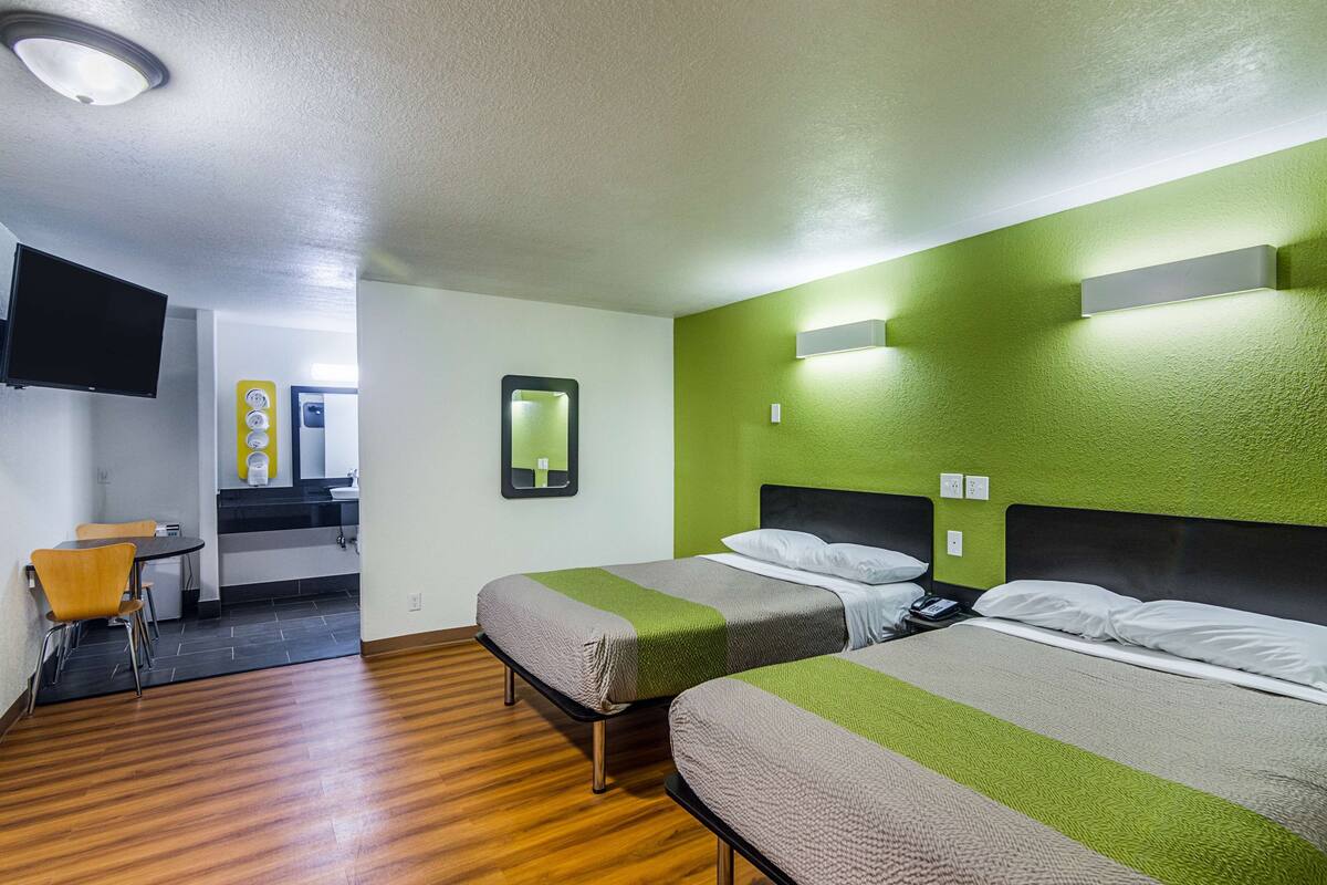 Ett hotellrum med två sängar, en liten matplats och en TV.