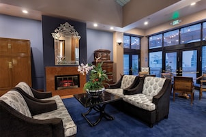 A lobby with a fireplace, seating area, and large windows offering a view.