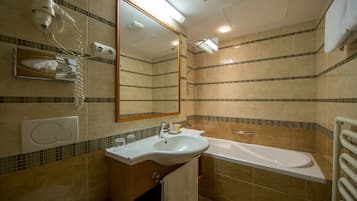 Un baño con lavabo, espejo y bañera.