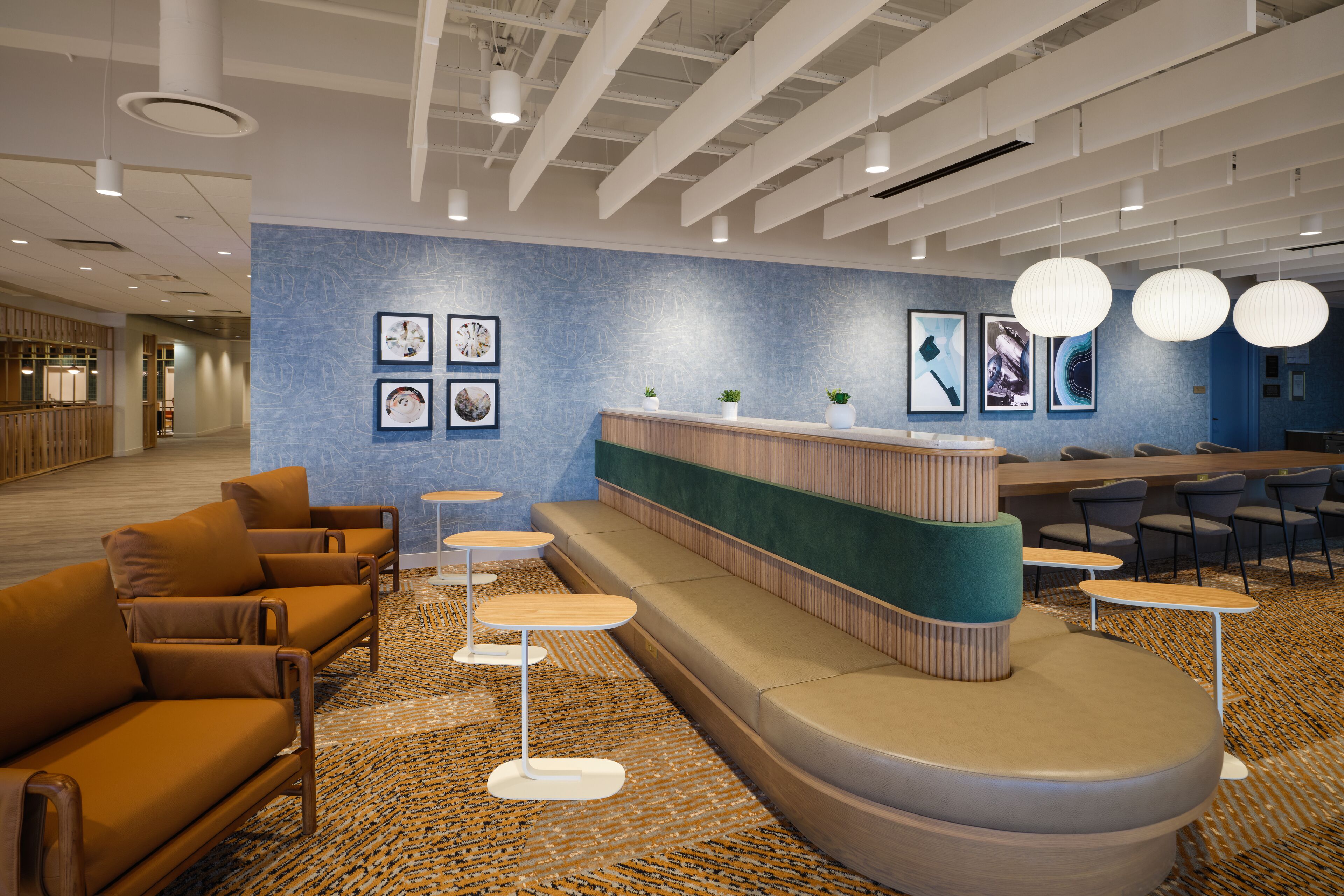 A modern reception area with a curved seating area, a reception desk, and multiple tables.