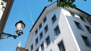 A white building with multiple windows and a street lamp. - Boutique Hotel Helmhaus Zurich (Zürich)