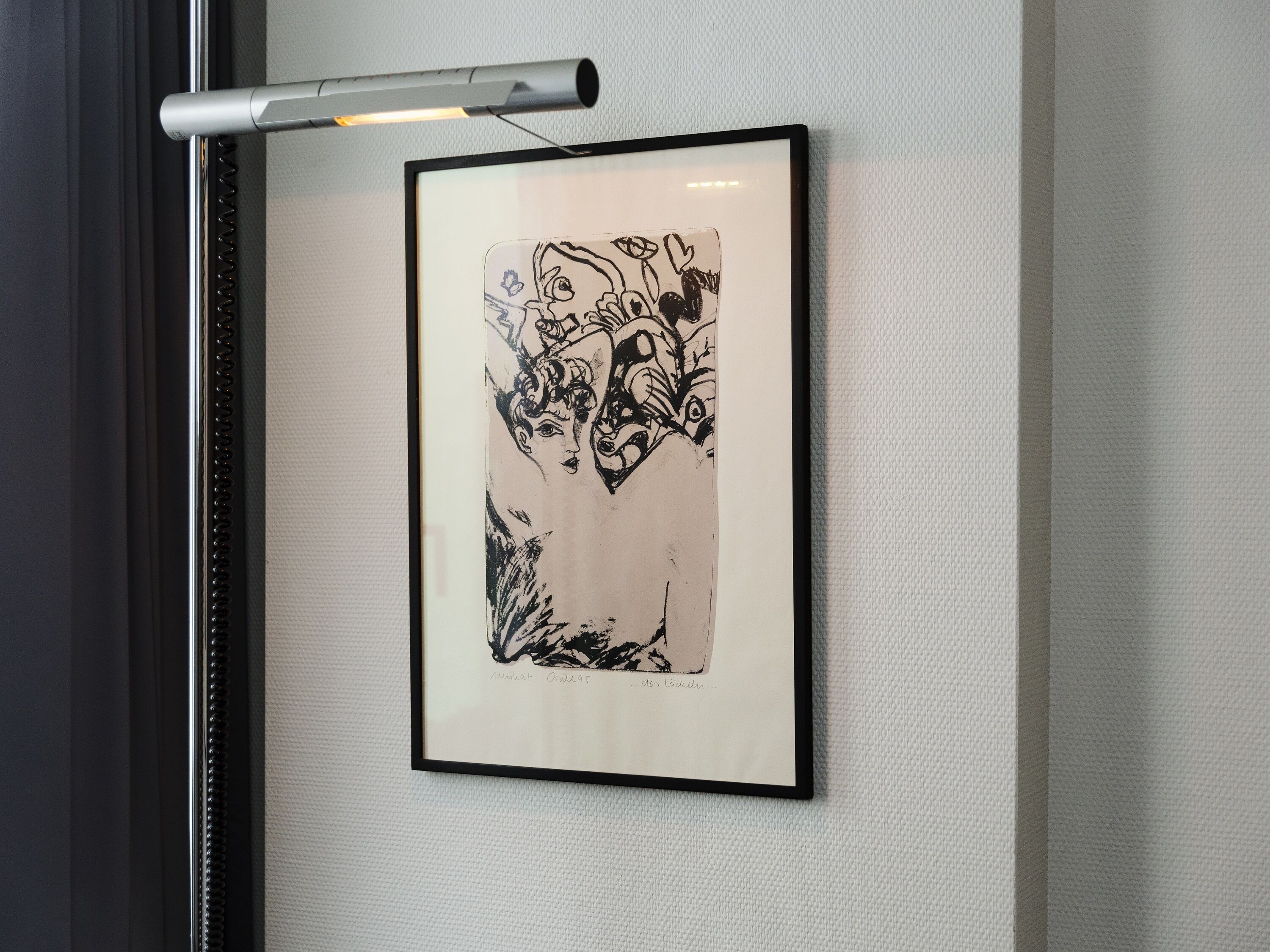 A framed artwork on a textured wall.