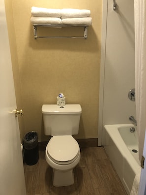 Bathroom features a white toilet, bathtub, and towel rack.