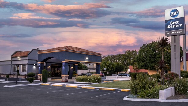 Ein Best Western Inn Santa Clara mit blauem Himmel und Parkplatz.