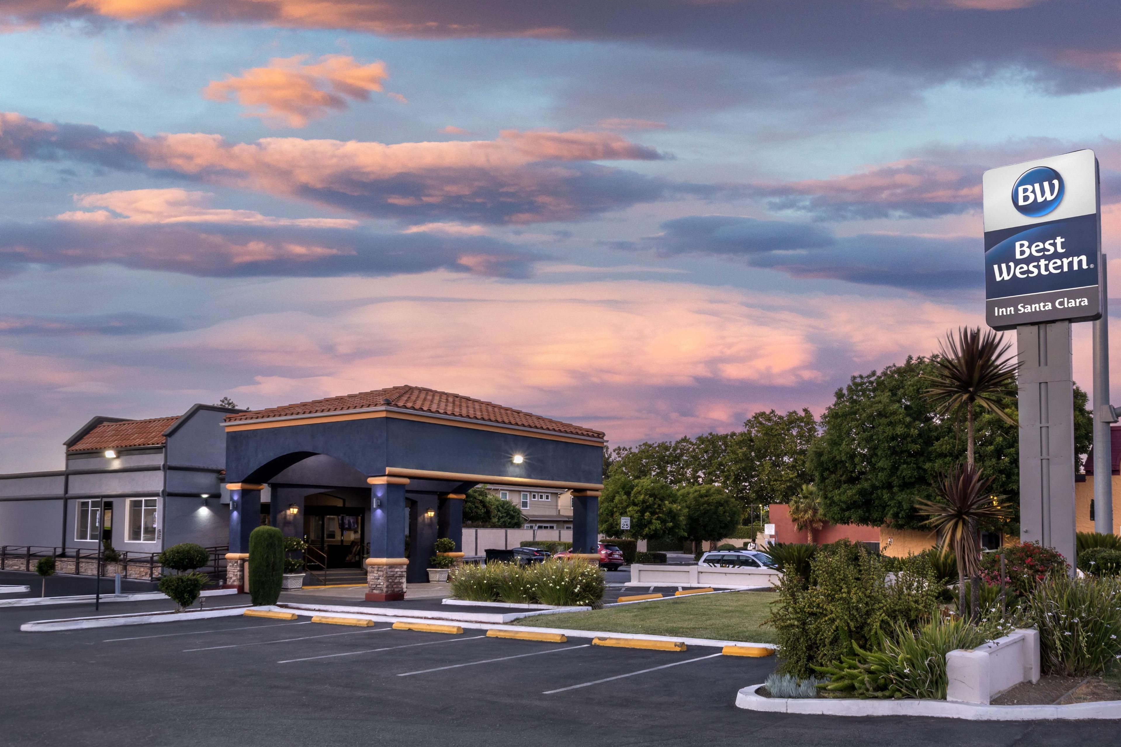 A Best Western Inn Santa Clara with a clear sky and parking lot.
