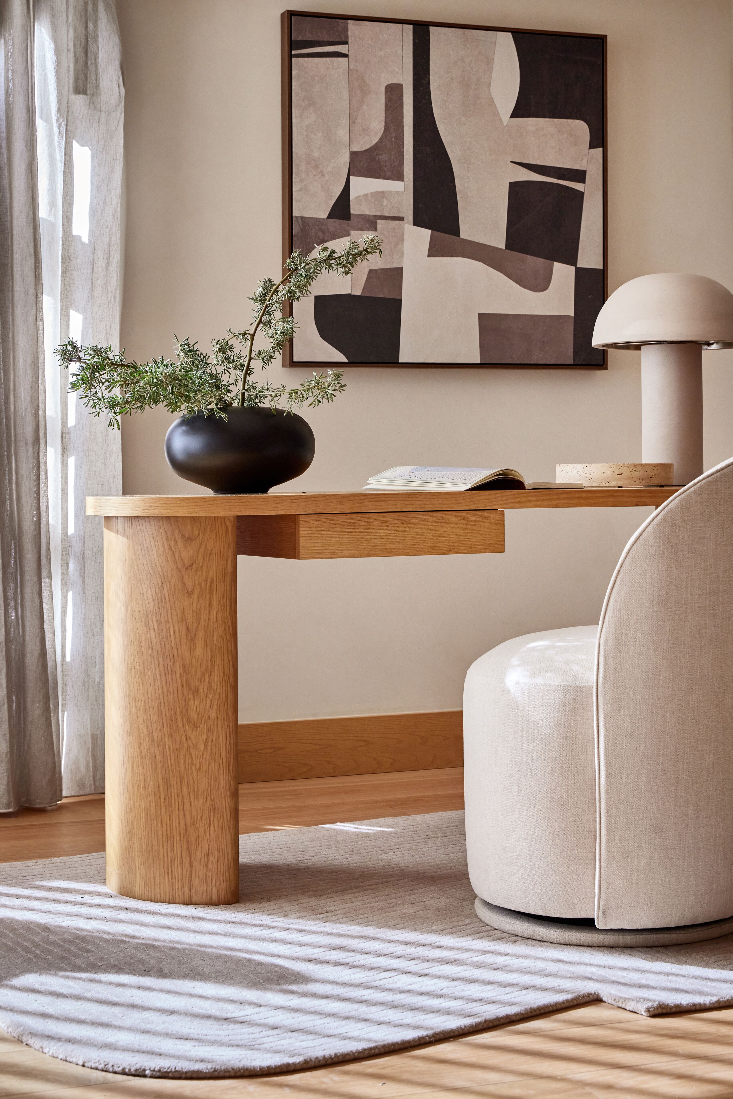 Une pièce moderne avec une table en bois, une chaise ronde, une plante en pot et une lampe fixée au mur.