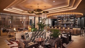 A modern lounge area with a bar, seating arrangements, and a wooden ceiling design. - The Jay, Autograph Collection (San Francisco)