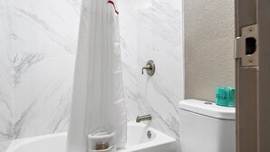 A bathroom with a bathtub, toilet, and a shower curtain. - Red Roof Inn Tampa Fairgrounds – Casino (Tampa)