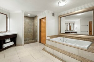 Un baño moderno con una bañera grande, una zona de ducha separada y un lavamanos con espejo.