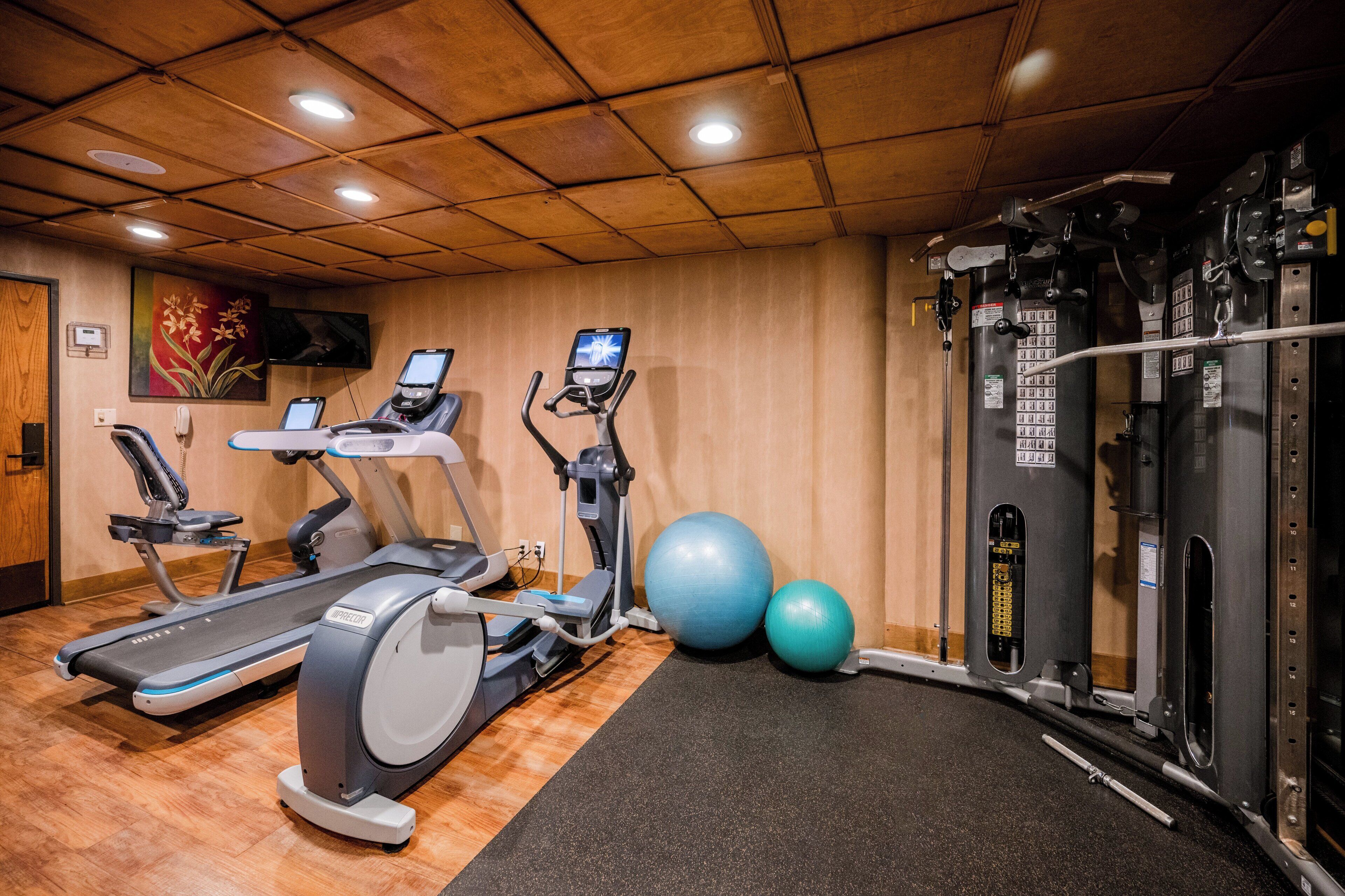 A gym with treadmills, elliptical machines, and a weight machine.