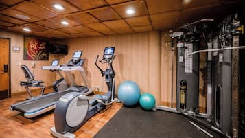 A gym with treadmills, elliptical machines, and a weight machine.