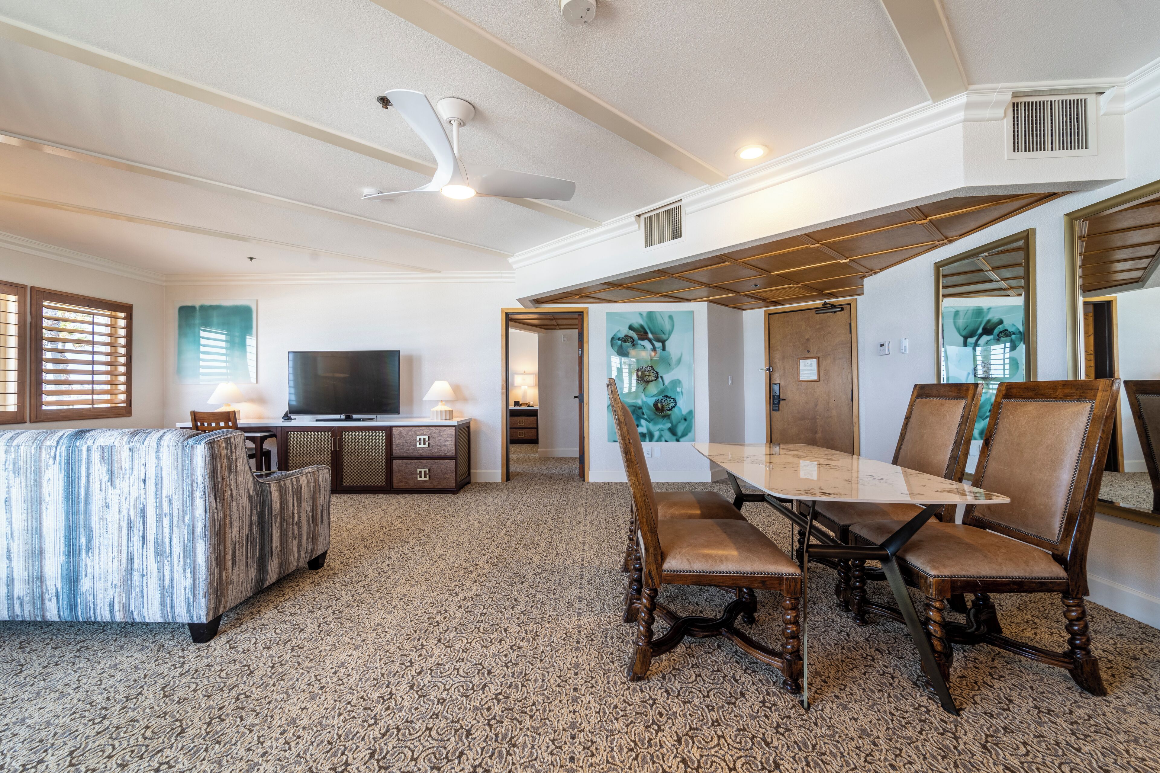 A spacious living room with a large TV, comfortable seating, and a dining area with a table and chairs.