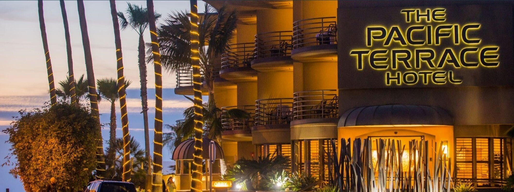 The Pacific Terrace Hotel with a prominent sign, multiple balconies, and palm trees.