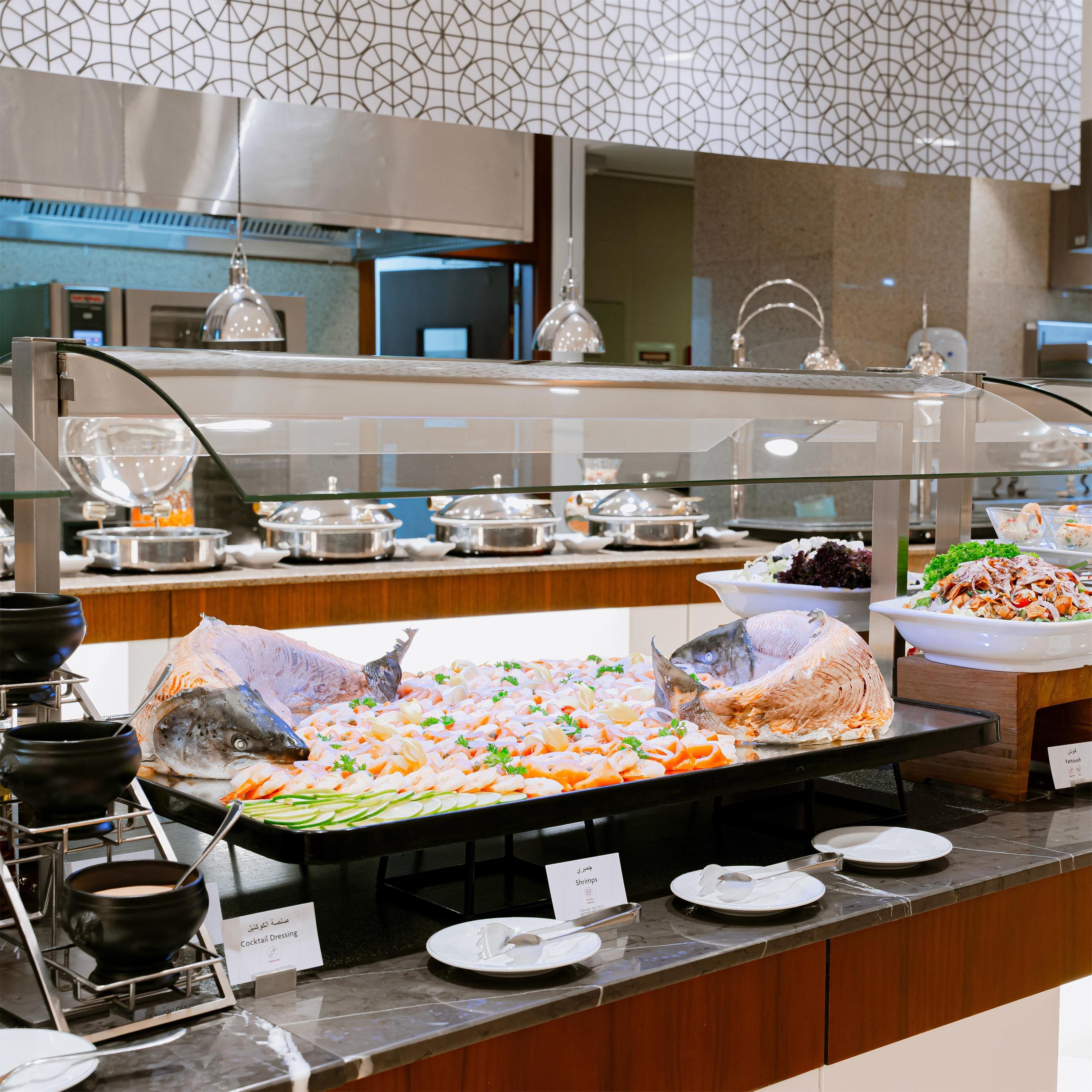 A buffet area with seafood options, including shrimp and fish, and a cocktail station.