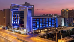 A modern hotel with a prominent entrance and illuminated signage.