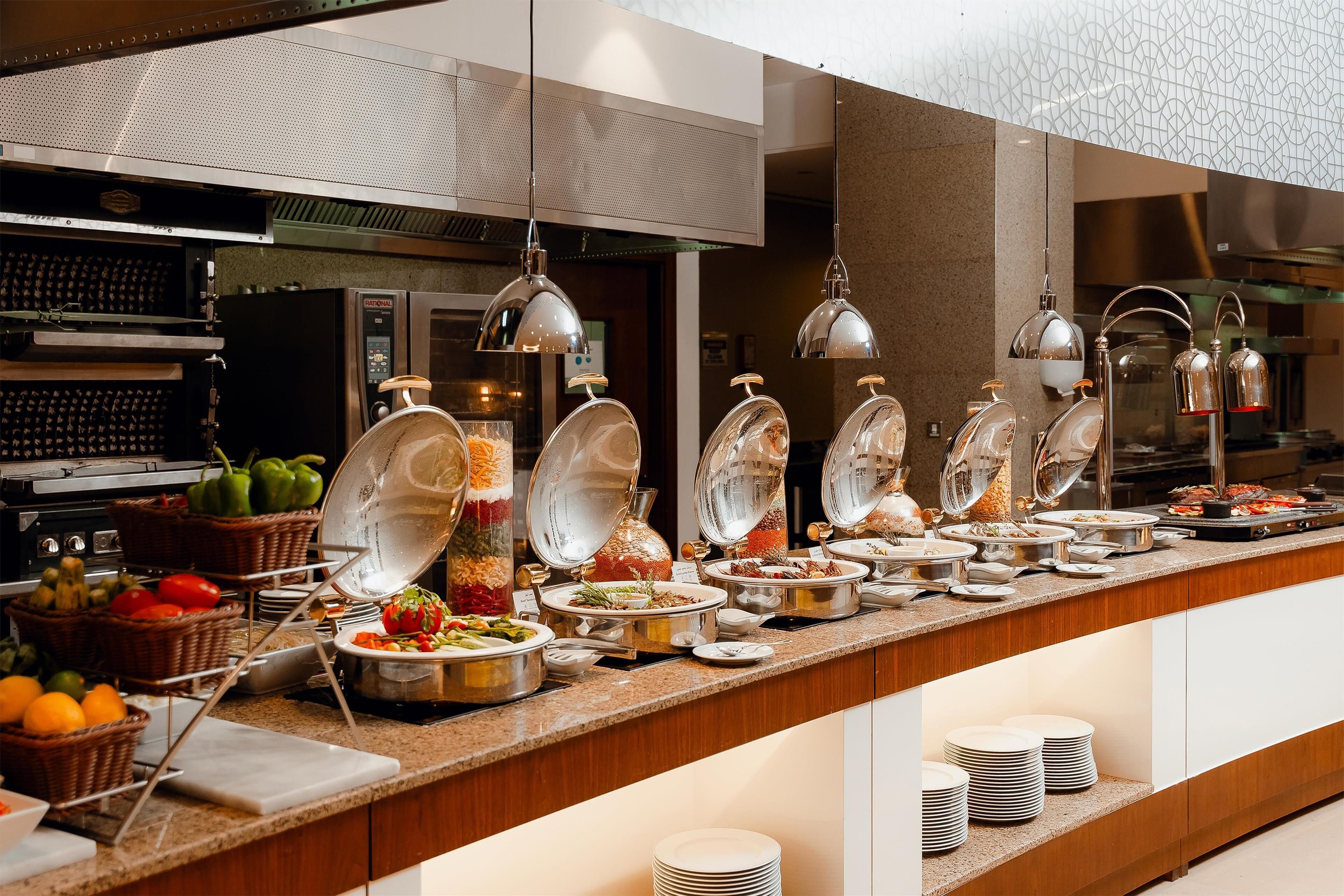 A buffet setup with various food items and serving utensils.