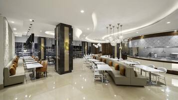 Un restaurante moderno con una barra larga, varias zonas de estar y vistas a la ciudad.