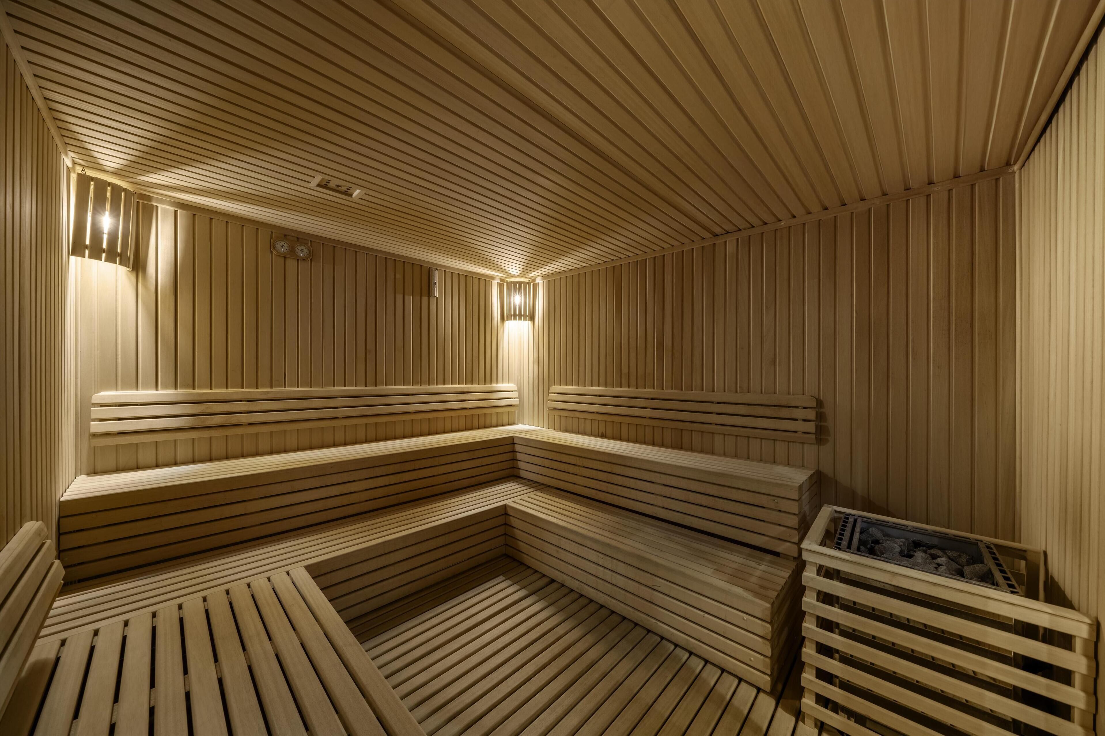 A sauna with wooden benches and a bench with a heating element.