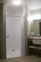 Baño con ducha, lavamanos y espejo.