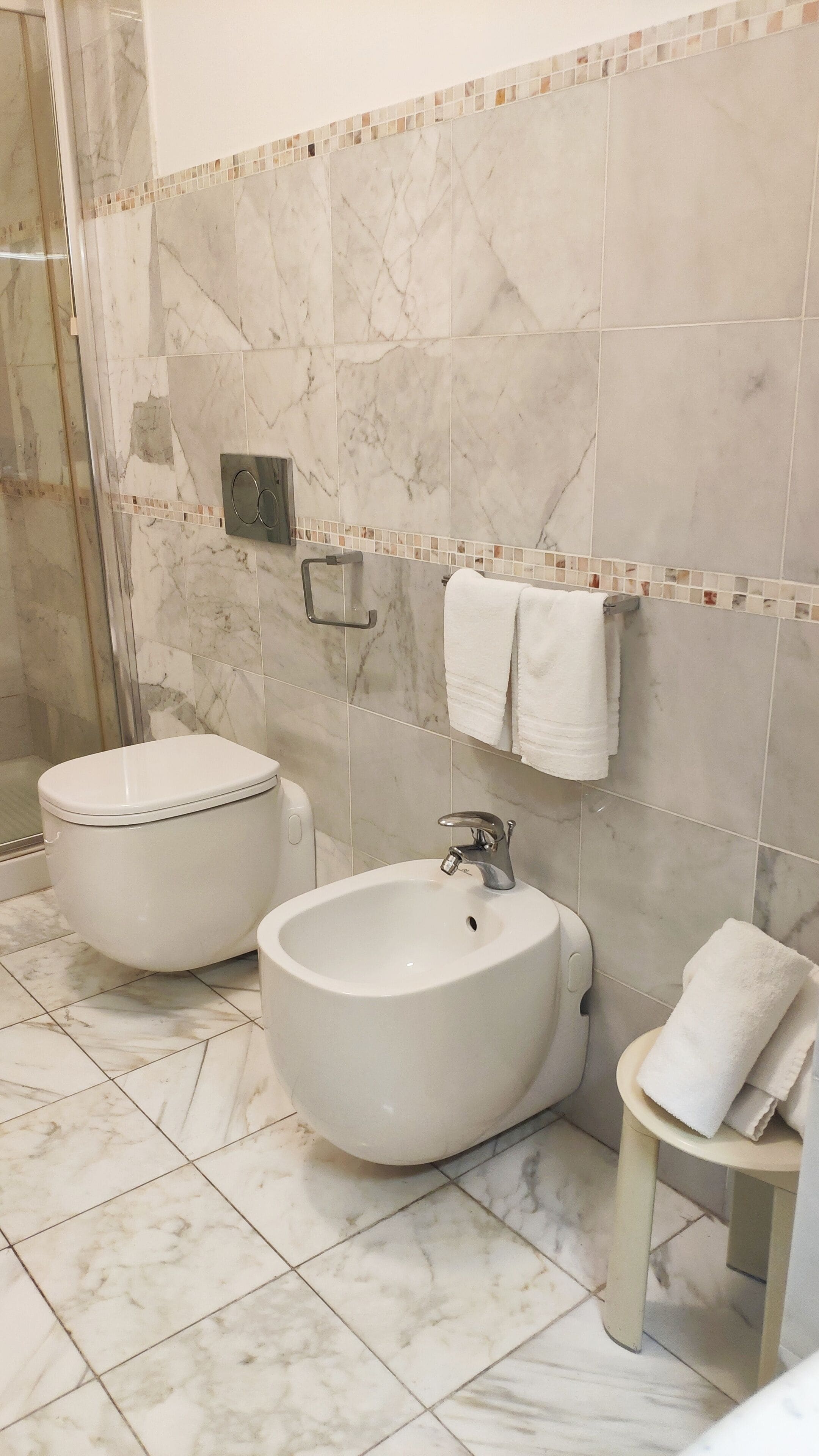 A bathroom with a toilet, bidet, and sink.