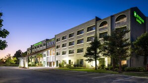 Een Wyndham Garden hotel met een modern design, met meerdere balkons en een parkeerplaats.
