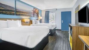 A hotel room with a large bed, a desk, a TV, and a painting of a landscape. - Days Inn by Wyndham Raleigh Glenwood-Crabtree (Raleigh)