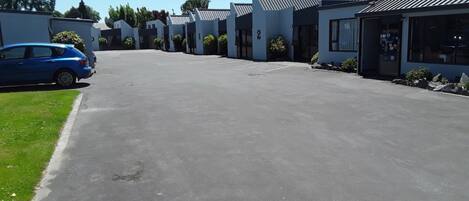 Una hilera de edificios modernos de una sola planta con puertas numeradas, probablemente parte de un hotel o complejo residencial.