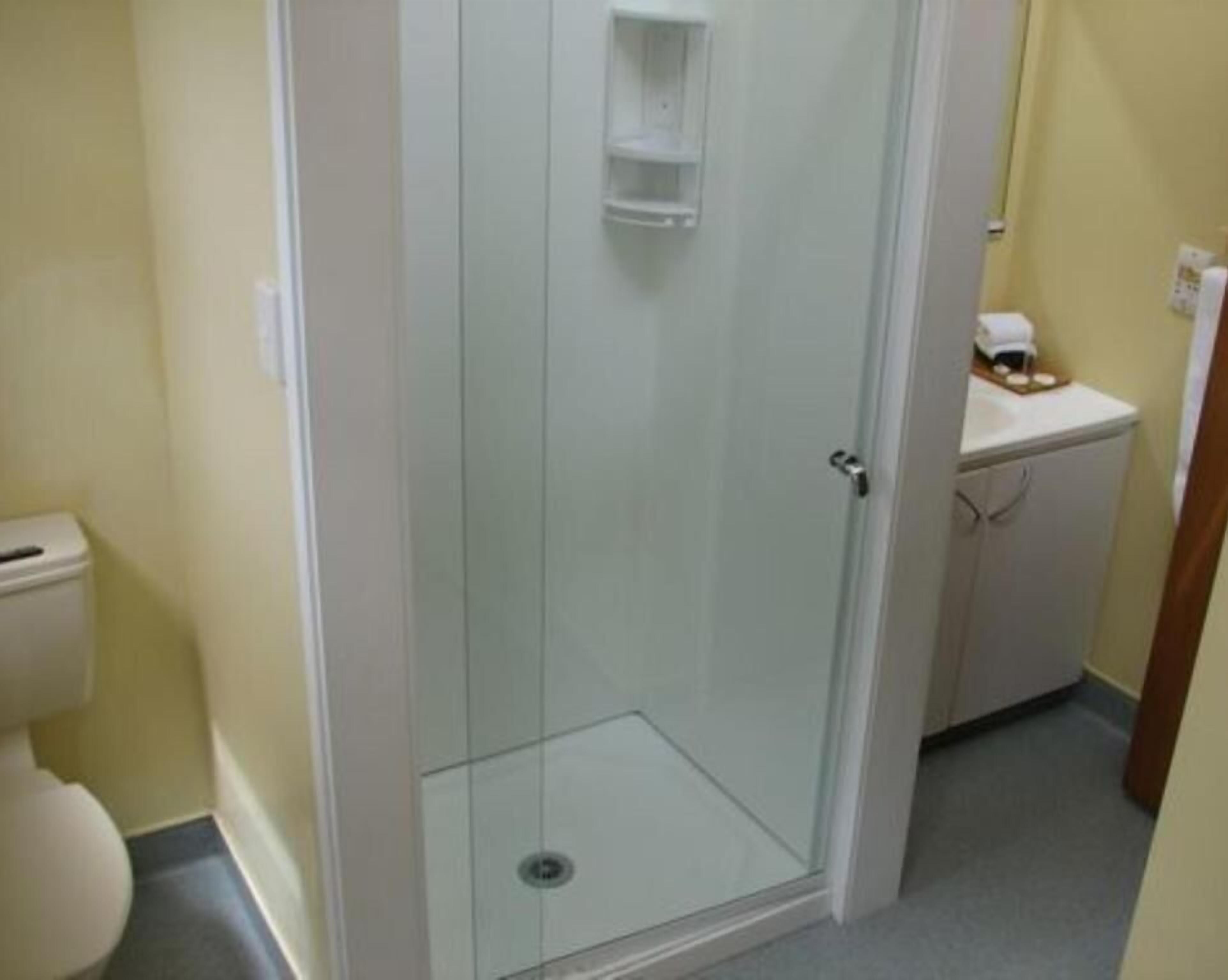 Ein Badezimmer mit Duschkabine, Toilette und Waschbecken.
