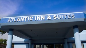 The exterior of the Atlantic Inn & Suites with a clear blue sky in the background. - Atlantic Inn & Suites (Belmar)