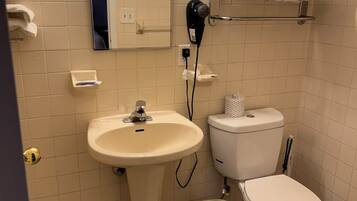 Een badkamer met een wastafel, toilet en een spiegel boven de wastafel.