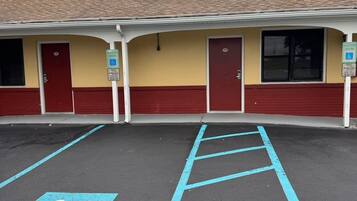 A building with a parking lot featuring blue handicapped parking spaces and a wheelchair-accessible ramp.