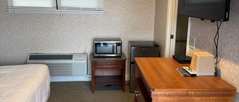 Une chambre d’hôtel équipée d’un lit, d’un bureau, d’une télévision et d’un radiateur.