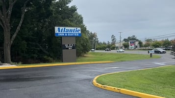Un camino que lleva a una propiedad con un letrero de Atlantic Inn & Suites.