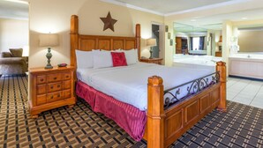A hotel room with a large bed, wooden headboard, a dresser, and a mirror.