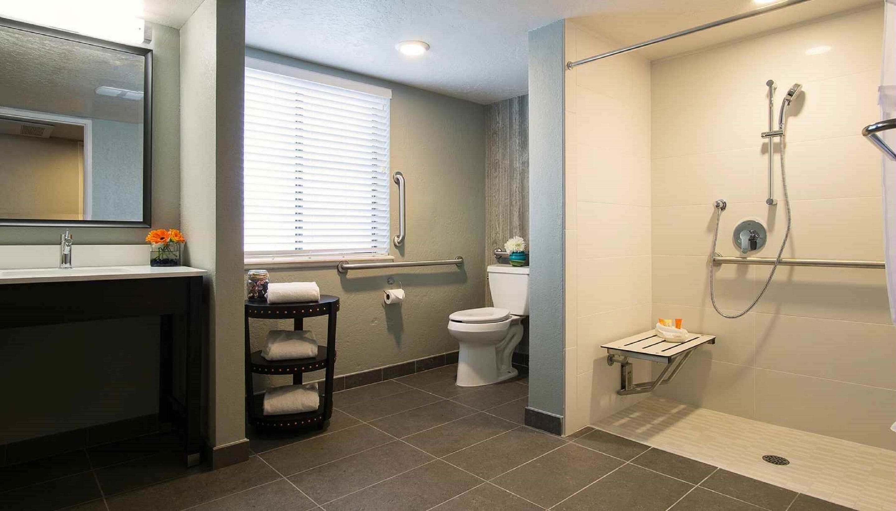 A modern bathroom with a shower, toilet, and sink.
